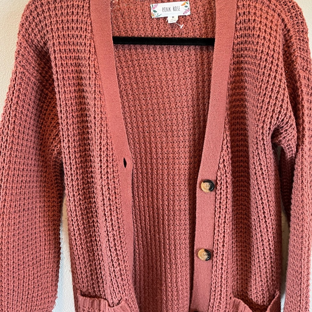 Pink open sweater.